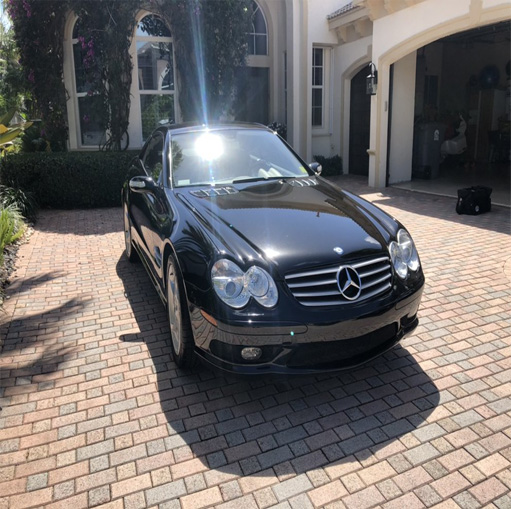 Black Mercedes Benz car parked in a luxurious driveway, showcasing Broward Detailers' premium car detailing services in South Florida.