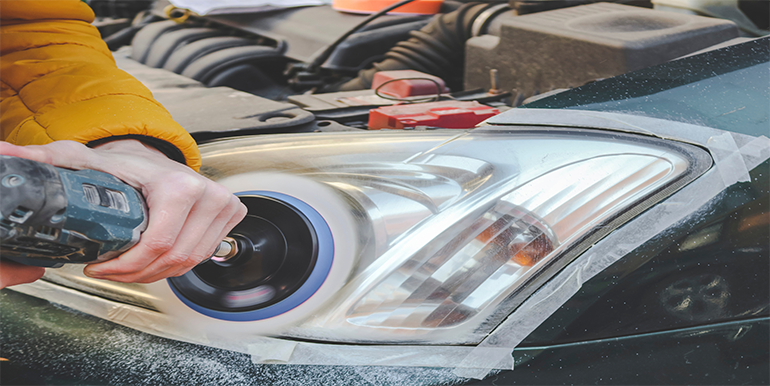 Professional headlight restoration process in South Florida, showcasing a technician polishing a car headlight to enhance clarity and improve visibility.