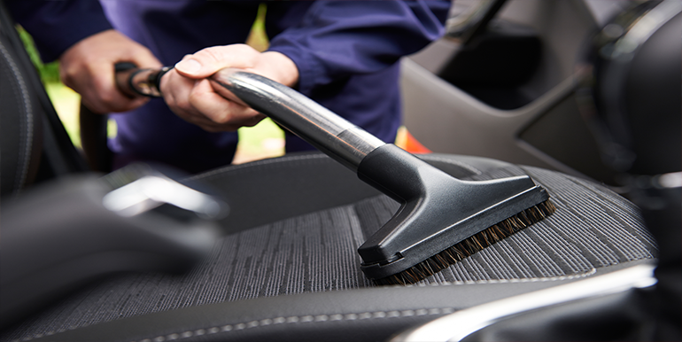 Professional pet hair removal service in South Florida, featuring a technician cleaning upholstery in a vehicle for a fresh and allergen-free interior.