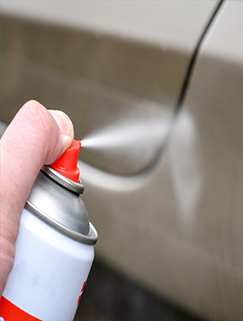 Professional degreasing service in South Florida, applying cleaning spray to remove oil and grime from vehicle surfaces