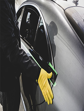 Technician performing chrome delete on a vehicle in South Florida, enhancing its sleek and modern look by removing chrome trim accents.