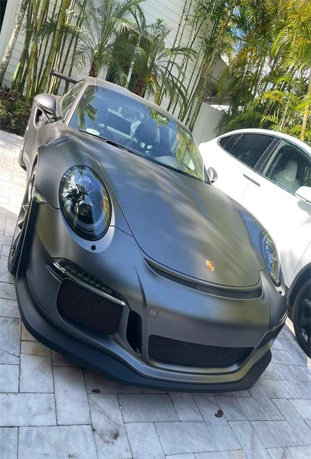 Premium car detailing service showcased by Broward Detailers, featuring a sleek matte black Porsche sports car in South Florida.